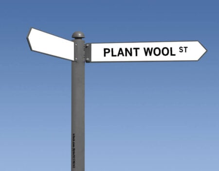 a white street sign reads "plant wool st"