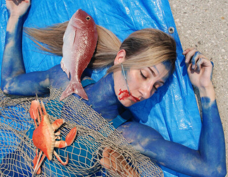 Protester with a "hook" in her mouth.